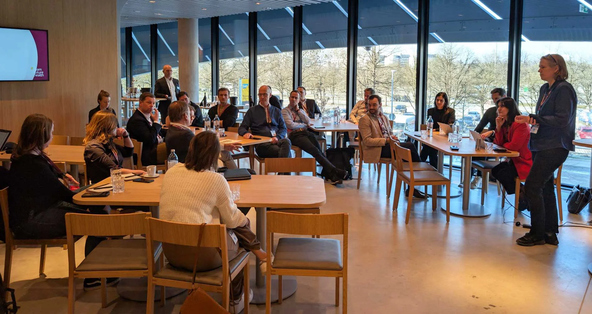 Messebesucher an Gruppentischen in einem Workshop